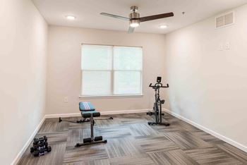 A room with a ceiling fan, a window, and exercise equipment. at Bickerstaff Crossing Apartments, Henrico, Virginia